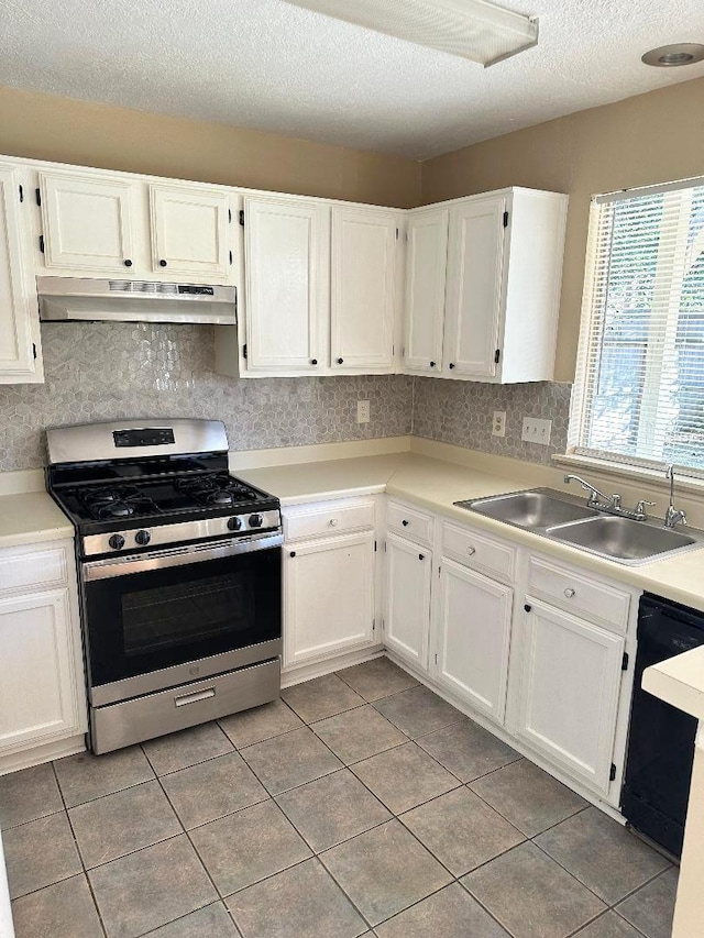 kitchen featuring dishwasher, gas stove, sink, white cabinetry, and light tile patterned floors