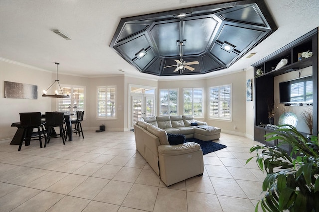 living room with light tile patterned floors, plenty of natural light, ceiling fan with notable chandelier, and ornamental molding