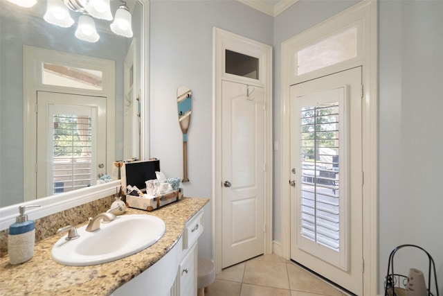 bathroom featuring tile patterned floors, vanity, ornamental molding, and a notable chandelier