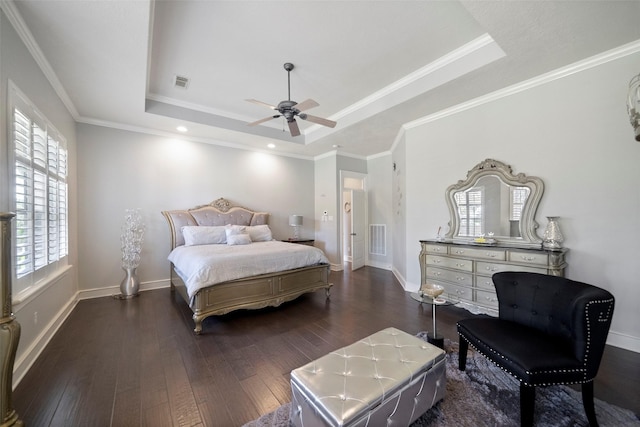 bedroom featuring ceiling fan, a tray ceiling, dark hardwood / wood-style flooring, and crown molding