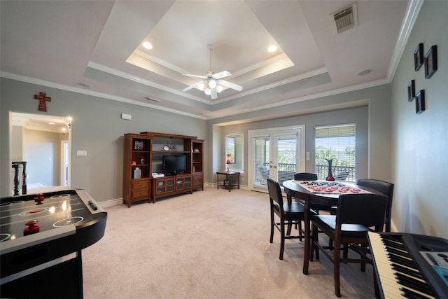 carpeted dining room featuring ceiling fan, ornamental molding, french doors, and a tray ceiling