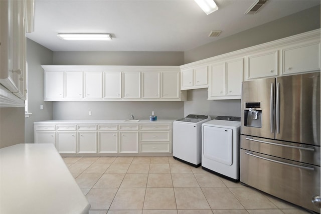 laundry room featuring light tile patterned floors and washer and clothes dryer