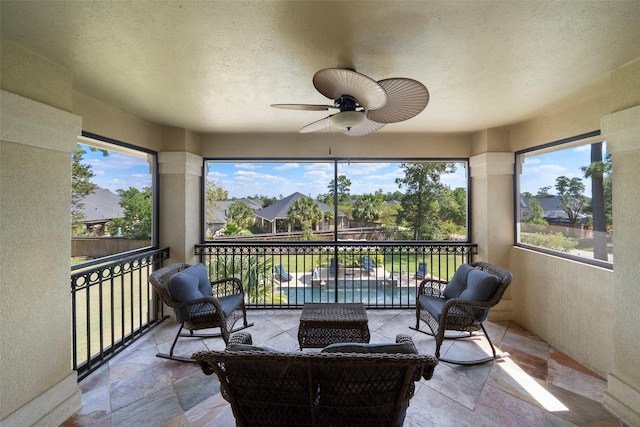 sunroom featuring ceiling fan and plenty of natural light