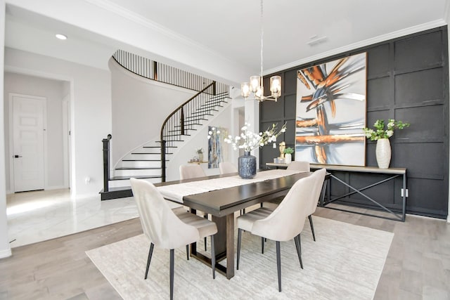 dining area with light hardwood / wood-style floors, crown molding, and a chandelier