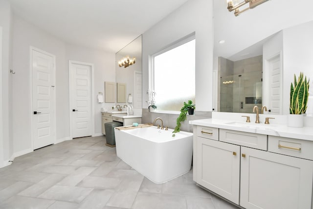 bathroom with independent shower and bath, an inviting chandelier, and vanity