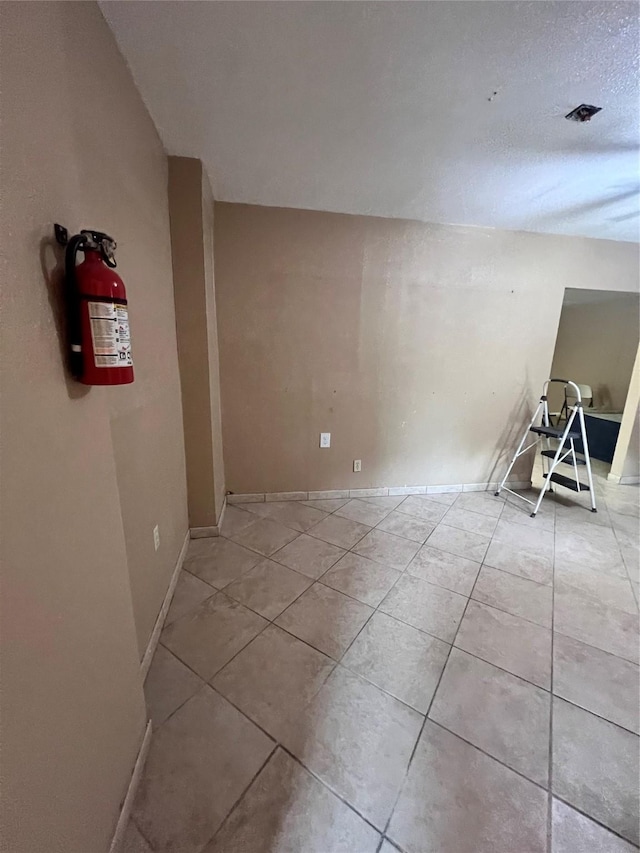 tiled spare room with a textured ceiling