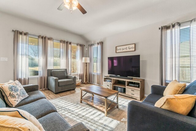 living room with ceiling fan, lofted ceiling, and light hardwood / wood-style floors