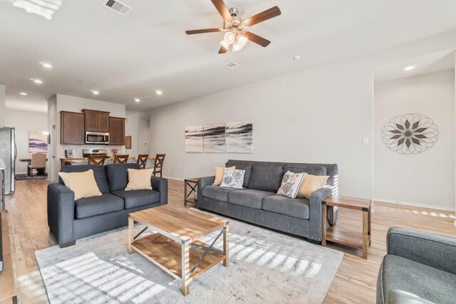 living room with ceiling fan and light hardwood / wood-style floors