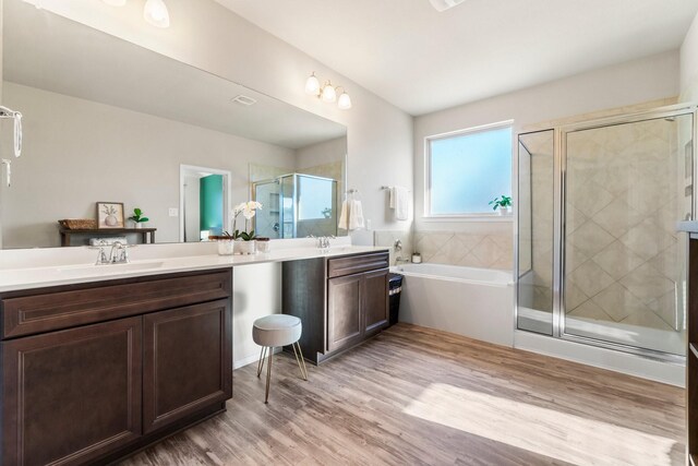 bathroom featuring independent shower and bath, vanity, and hardwood / wood-style floors