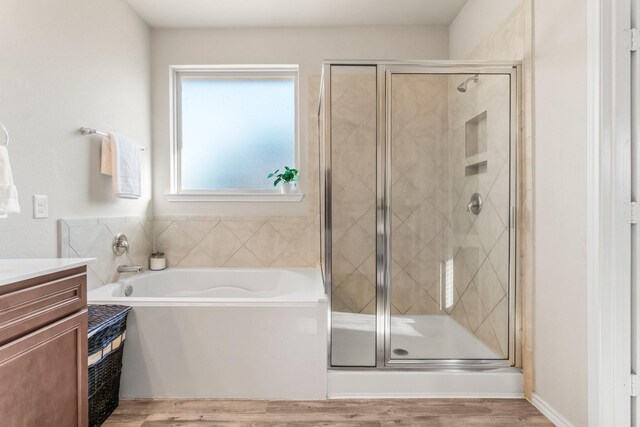 bathroom with vanity, hardwood / wood-style floors, and independent shower and bath