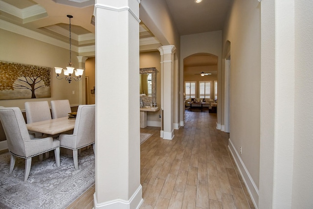 unfurnished dining area featuring coffered ceiling, ornamental molding, light hardwood / wood-style floors, and decorative columns