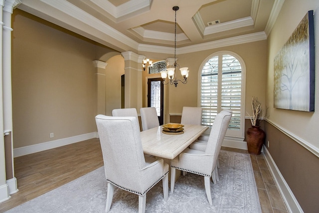 dining space featuring ornate columns, crown molding, coffered ceiling, and hardwood / wood-style floors