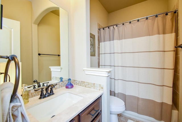 full bathroom with vanity, decorative backsplash, shower / bath combo, and toilet