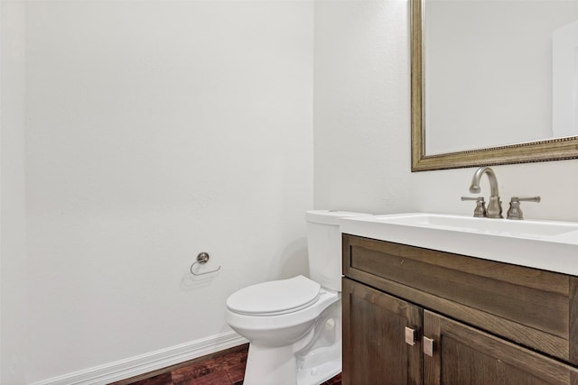 bathroom with vanity, hardwood / wood-style floors, and toilet