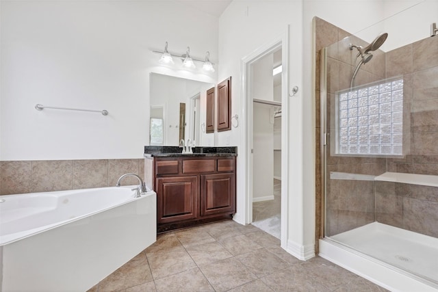 bathroom with tile patterned floors, vanity, and plus walk in shower