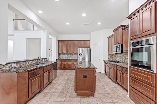 kitchen featuring tasteful backsplash, appliances with stainless steel finishes, kitchen peninsula, and dark stone counters