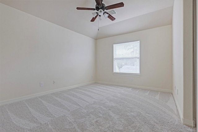 empty room with ceiling fan, vaulted ceiling, and light carpet