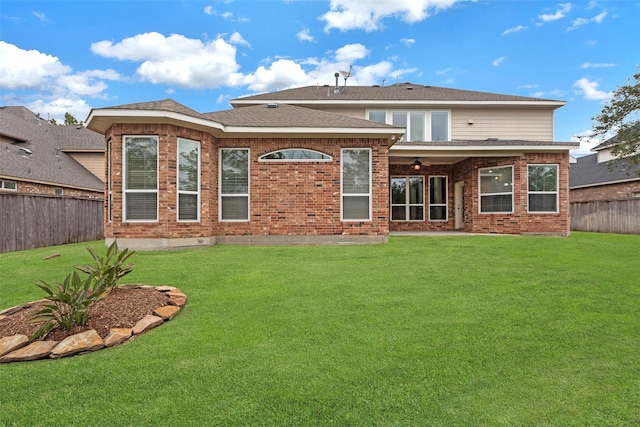 back of property featuring a lawn and ceiling fan