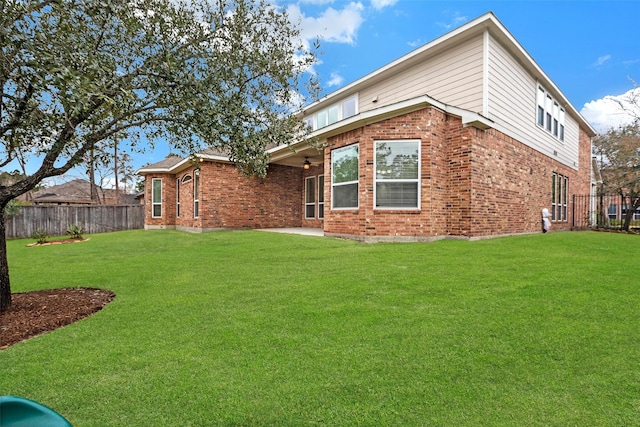 back of house with ceiling fan, a yard, and a patio