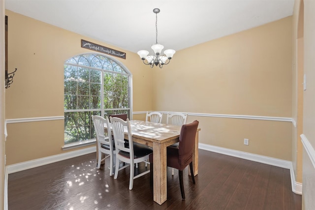 dining space featuring dark wood-type flooring, plenty of natural light, and a chandelier