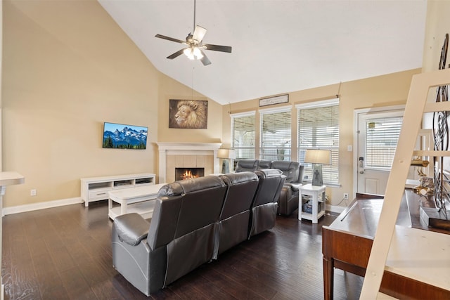 living room with high vaulted ceiling, a tiled fireplace, dark hardwood / wood-style floors, and ceiling fan