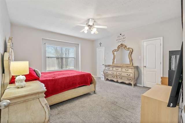 carpeted bedroom featuring ceiling fan and a textured ceiling