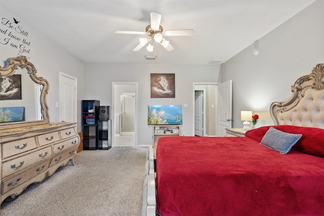 carpeted bedroom with ensuite bath and ceiling fan