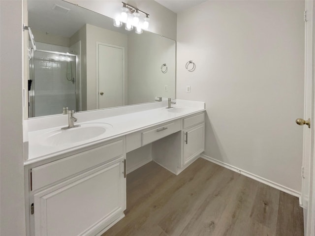 bathroom with hardwood / wood-style flooring, walk in shower, and vanity