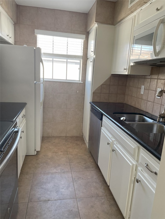 kitchen with decorative backsplash, sink, white appliances, white cabinetry, and light tile patterned floors