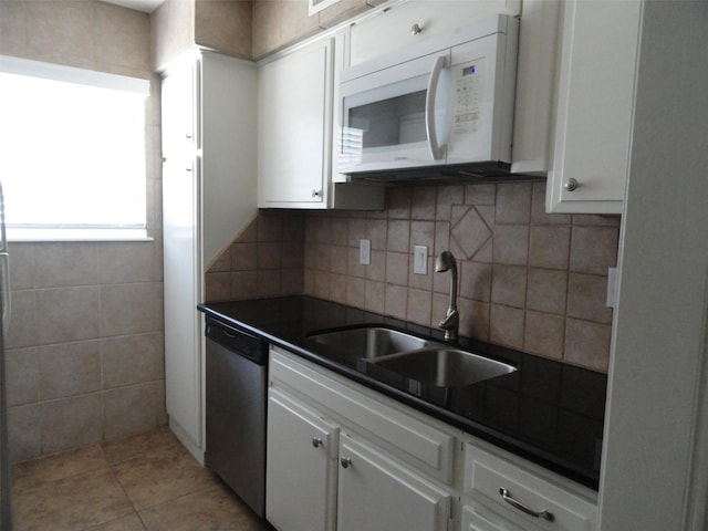 kitchen featuring white cabinets, dishwasher, tasteful backsplash, sink, and light tile patterned flooring