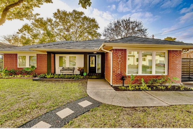 8614 Linkpass Ln, Houston, TX 77025 - ranch-style house featuring brick siding, a front lawn, and covered porch