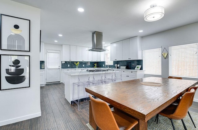 kitchen featuring tasteful backsplash, extractor fan, a center island, a breakfast bar, and white cabinets