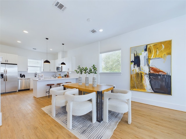 dining space featuring light wood-type flooring and a wealth of natural light