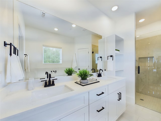 bathroom with walk in shower, vanity, and tile patterned floors