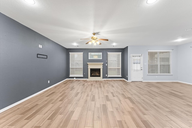 unfurnished living room featuring ceiling fan and light hardwood / wood-style floors