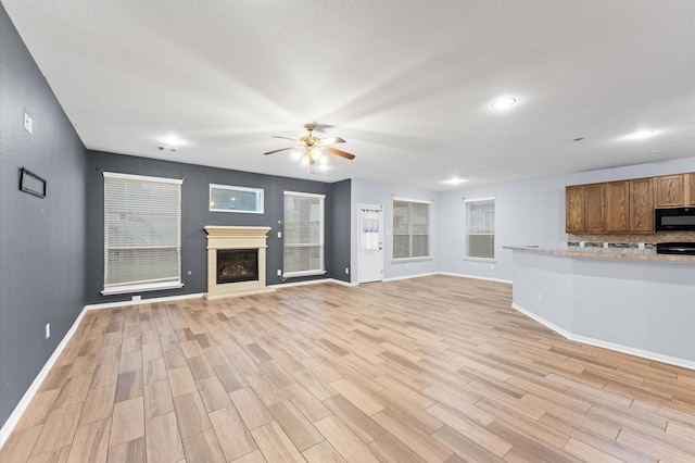 unfurnished living room featuring light hardwood / wood-style floors and ceiling fan