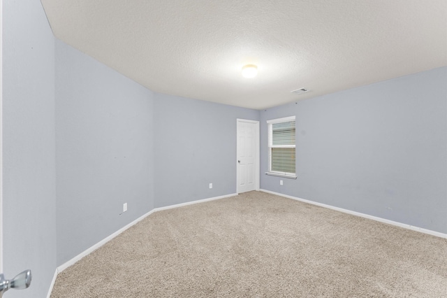 unfurnished room with carpet and a textured ceiling