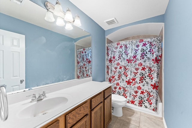 bathroom with toilet, vanity, and tile patterned floors