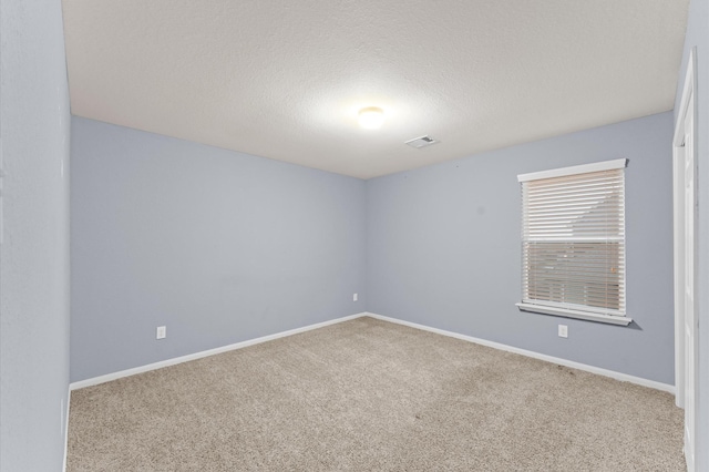 empty room featuring carpet floors and a textured ceiling