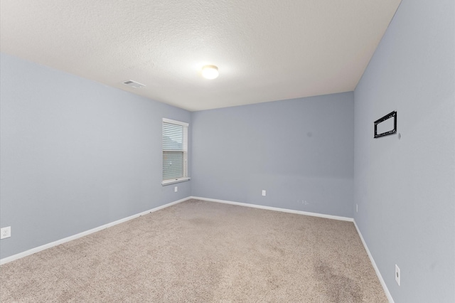 carpeted empty room with a textured ceiling