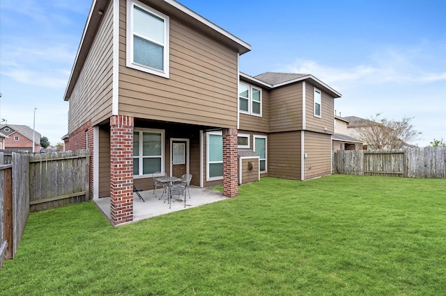 rear view of house featuring a lawn and a patio