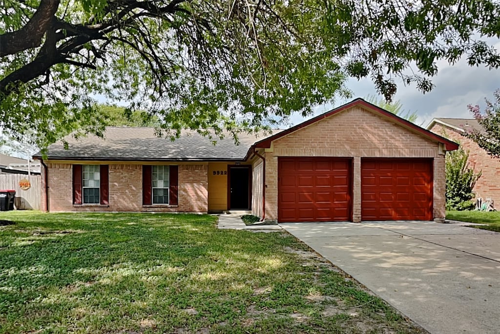 single story home with a front yard and a garage