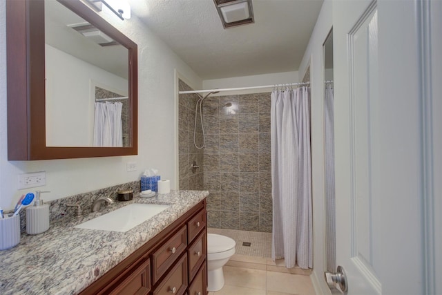 bathroom featuring toilet, vanity, a shower with shower curtain, and tile patterned flooring