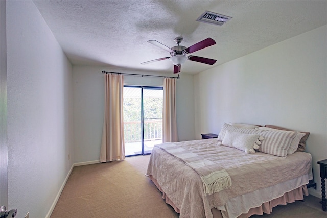 bedroom featuring ceiling fan, a textured ceiling, light carpet, and access to outside