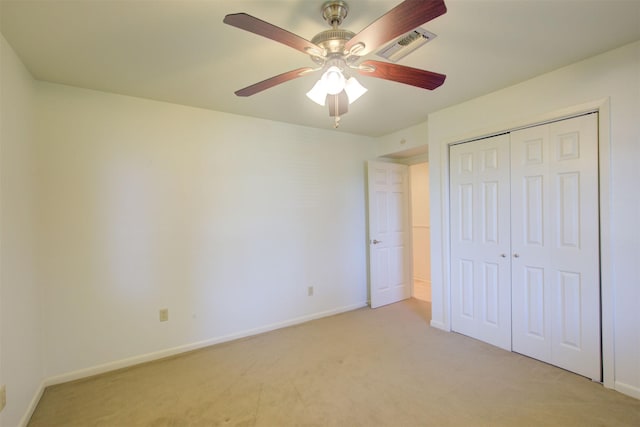 unfurnished bedroom featuring ceiling fan, light colored carpet, and a closet