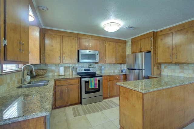 kitchen with appliances with stainless steel finishes, decorative backsplash, sink, kitchen peninsula, and light stone counters