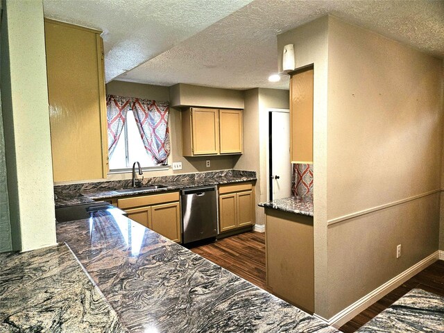 kitchen featuring sink, dark hardwood / wood-style flooring, a textured ceiling, light brown cabinetry, and stainless steel dishwasher