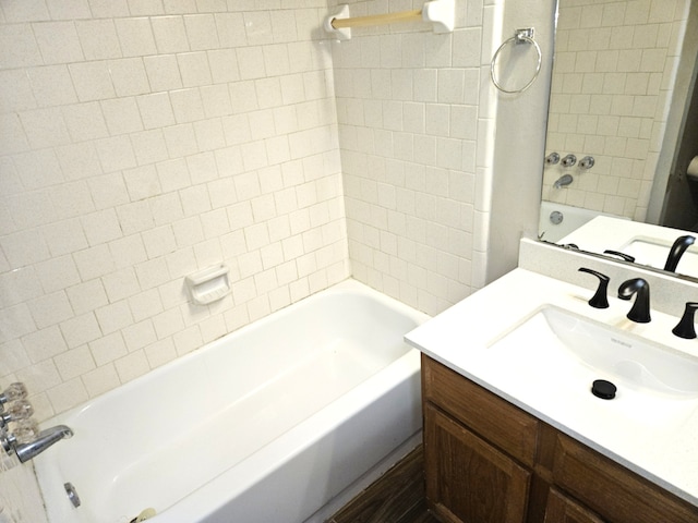 bathroom with tiled shower / bath combo and vanity