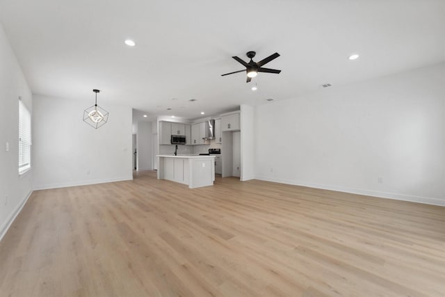 unfurnished living room with ceiling fan and light hardwood / wood-style flooring