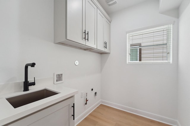 laundry area with washer hookup, cabinets, light hardwood / wood-style flooring, gas dryer hookup, and sink